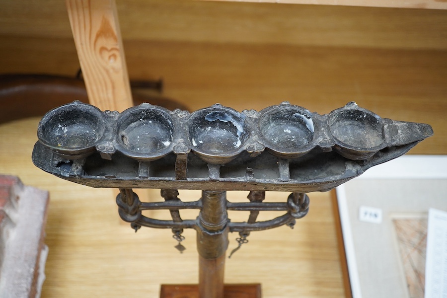 An 18th/19th century Indian Buddhist bronze oil lamp, on a later wood stand, 42.5cm high. Condition - fair